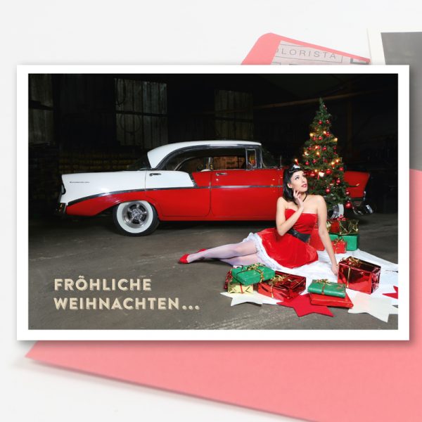 Weihnachts-Klappkarte mit rotem Umschlag. Hochglanz-Weihnachtskarte mit einem Cars & Girls Motiv im Format DIN A 6. Kalendermodel Sally und ein Chevrolet Bel Air von 1956
